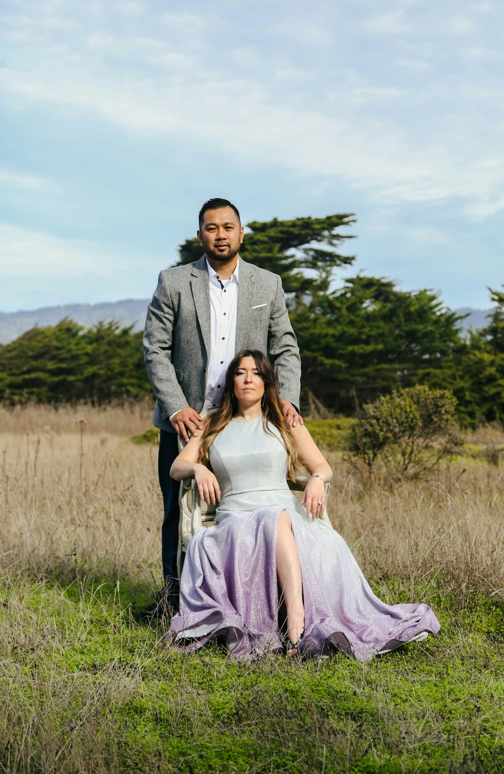 um homem e uma mulher posando para uma foto em um campo