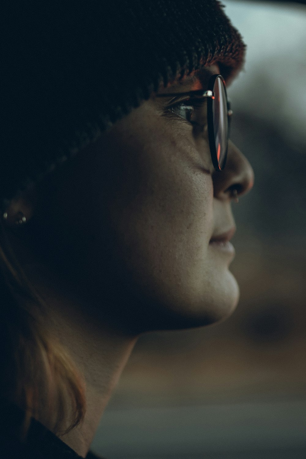 a close up of a person wearing a hat and glasses