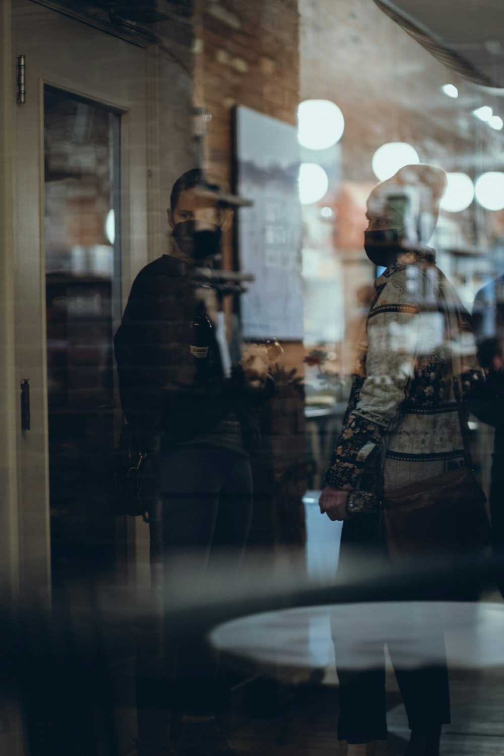 Un grupo de personas de pie frente a la ventana de una tienda