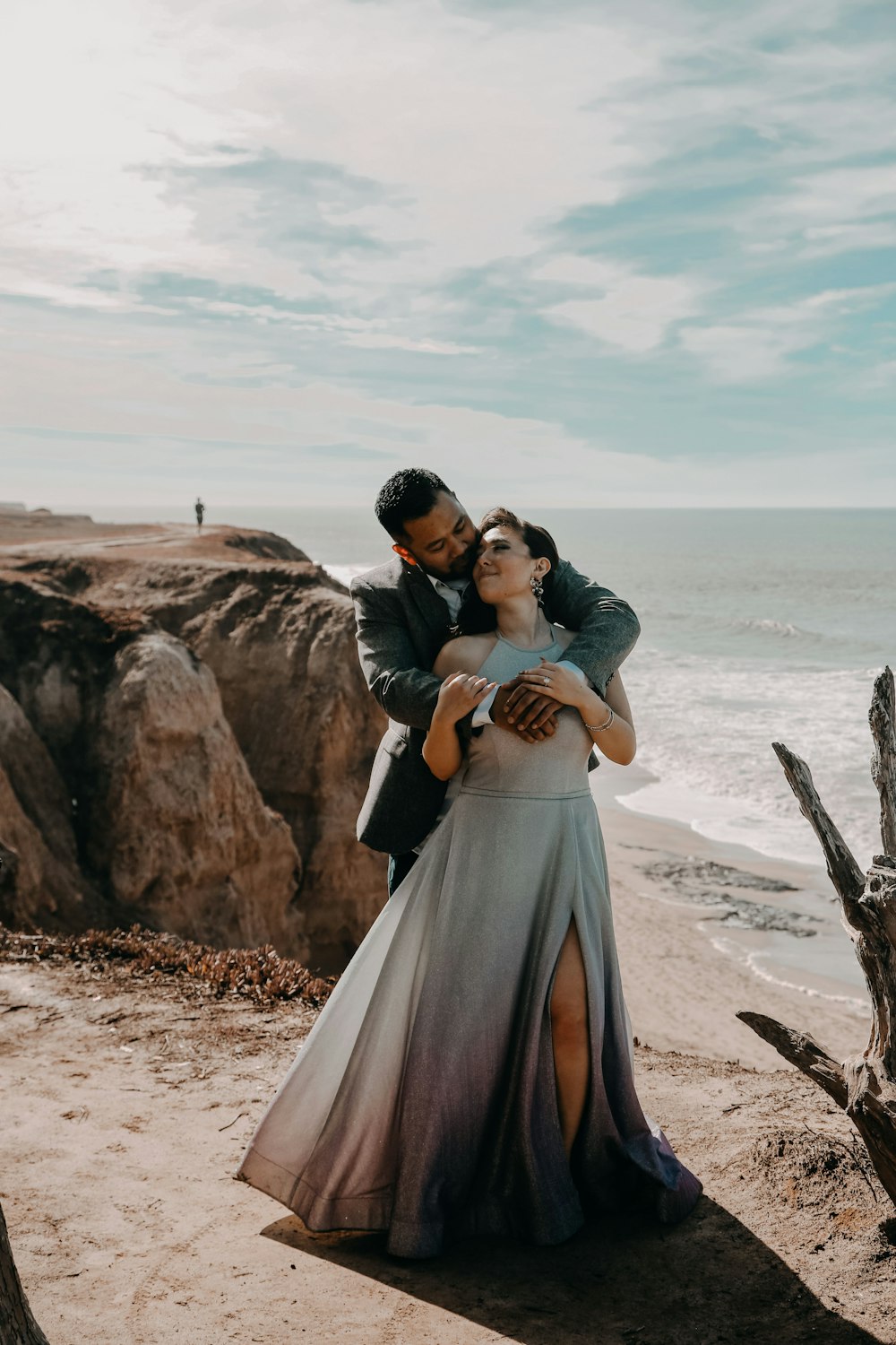 a man and a woman hugging on the beach