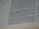 The close-up image displays a page of a book with text printed in black ink. The paper appears slightly off-white and lined margins are visible on the left side of the page. The photograph is focused more on the lower portion of the text, with some parts appearing slightly blurred.