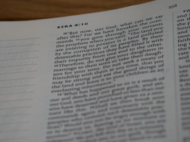 An open page of a Bible with visible chapter and verse numbers. The passage features text from the book of Ezra, specifically chapter 9, verses 10 to 12, running across two columns on white paper.