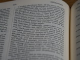 A close-up view of an open book showing the text from the Old Testament. The text is printed in black on cream-colored paper, with a two-column layout. The page numbers and section headers are visible at the top of the page.
