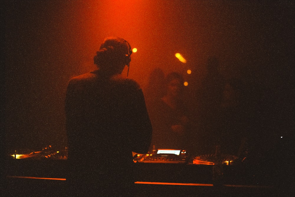 a dj mixing in front of a red light