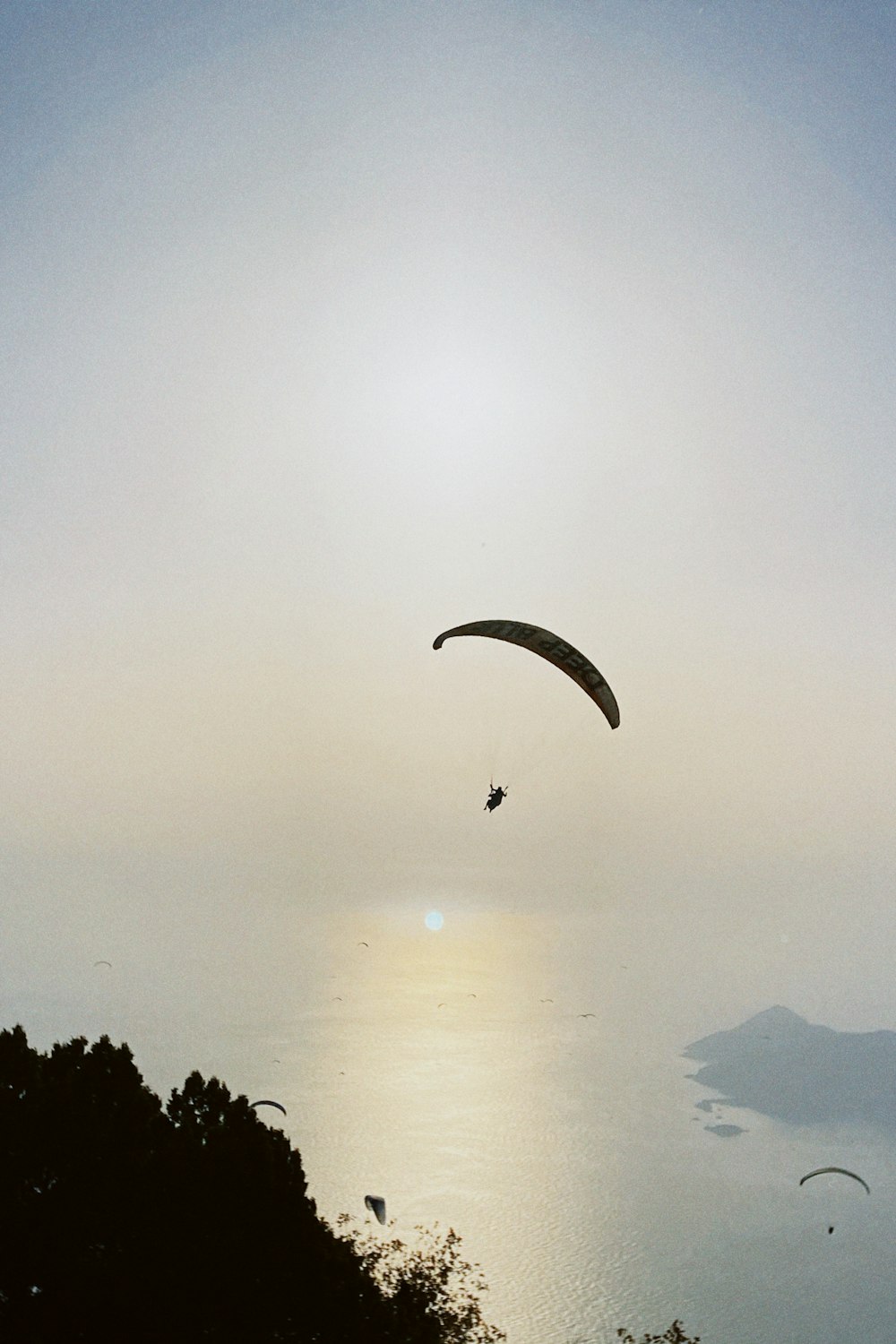 Un parapente survole un plan d’eau