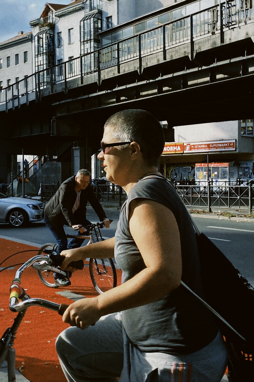 a couple of men riding bikes down a street