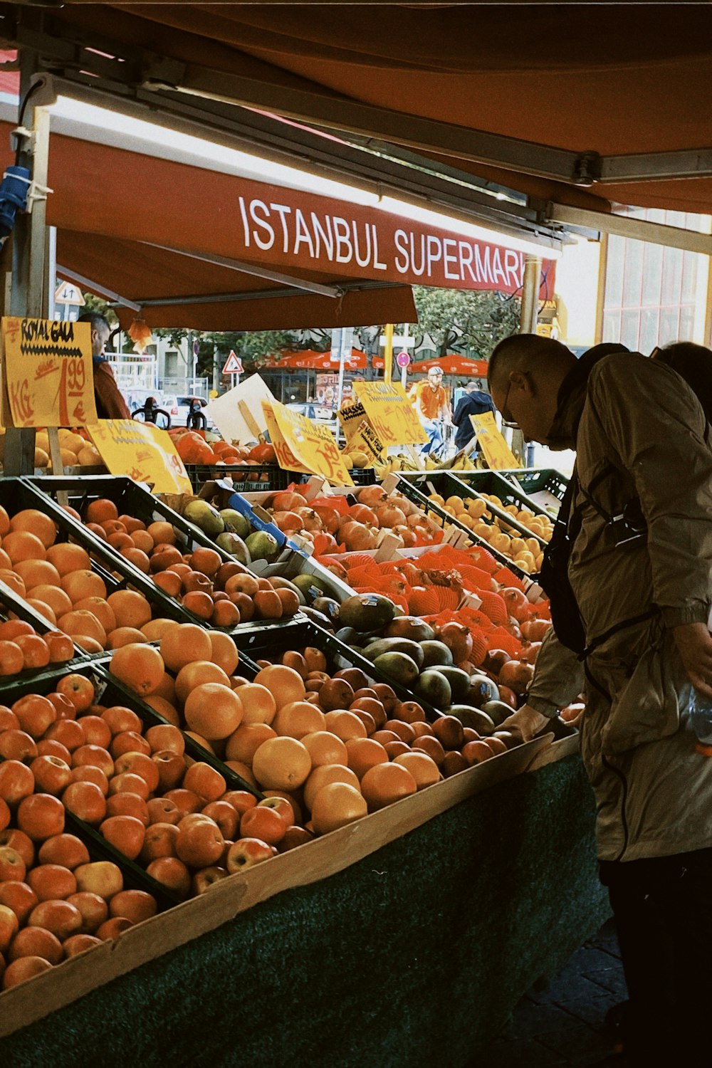 a man standing in front of a display of oranges