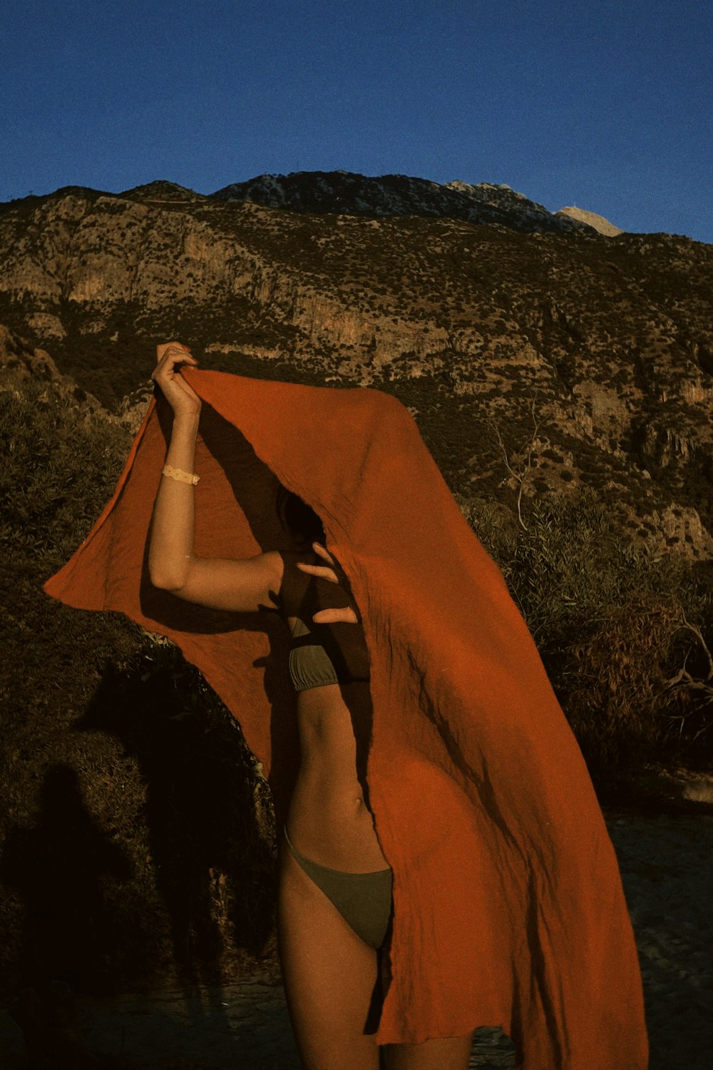 a woman in a bikini holding an orange towel