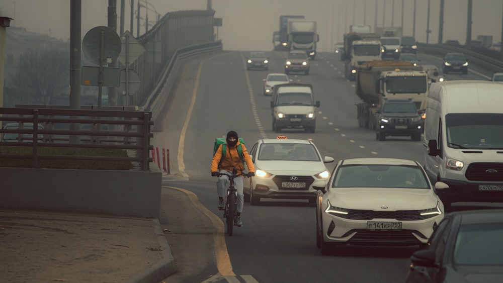 a person riding a bike on a busy highway