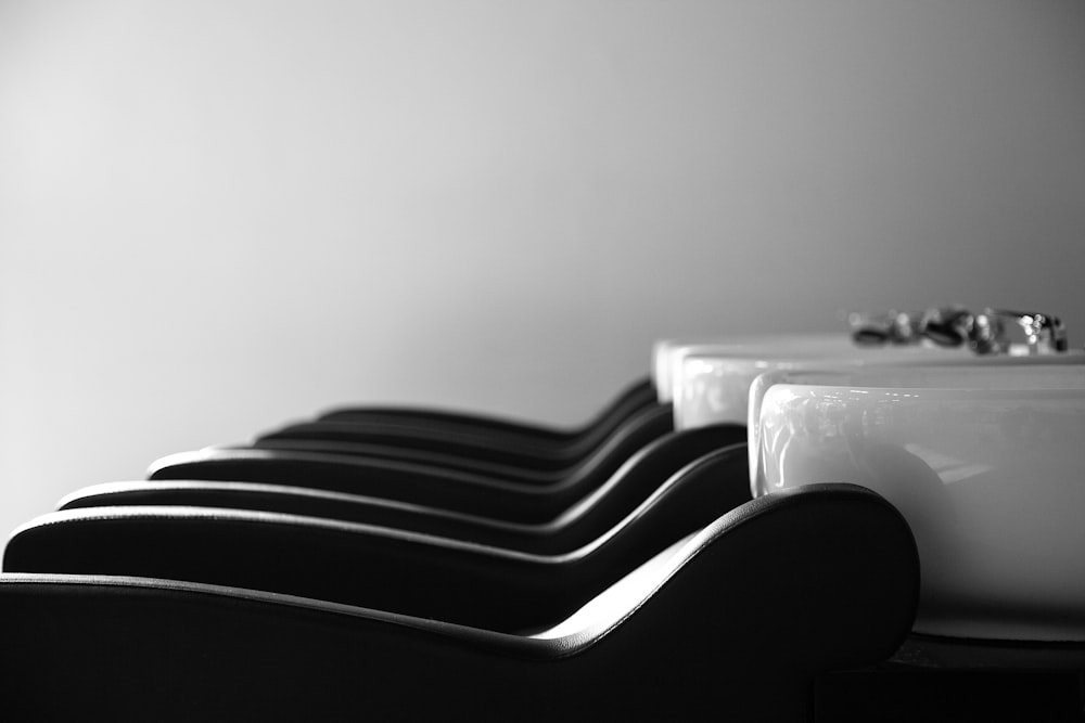 a row of black and white chairs next to a sink