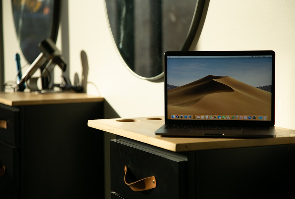 a laptop computer sitting on top of a wooden desk