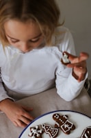 a little girl is eating some cookies on a plate