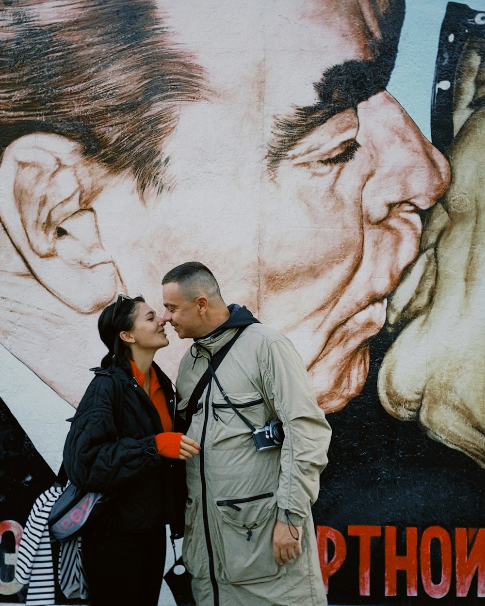 a man and a woman standing in front of a painting