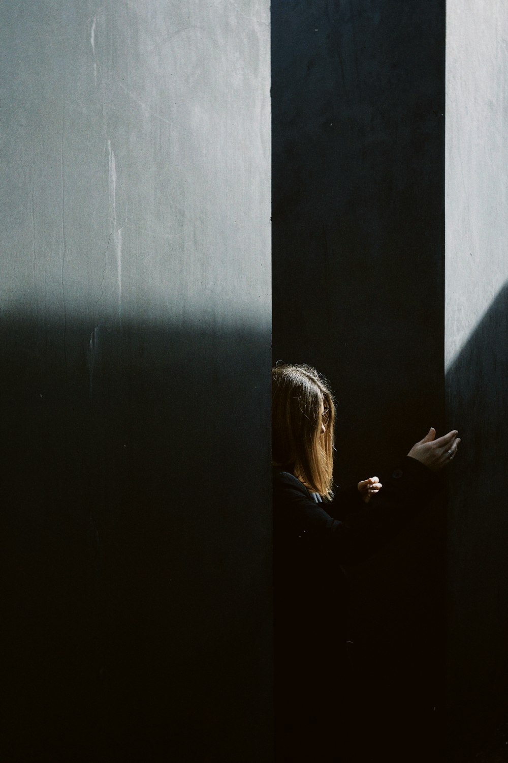 a woman standing in a doorway with her hand on the wall