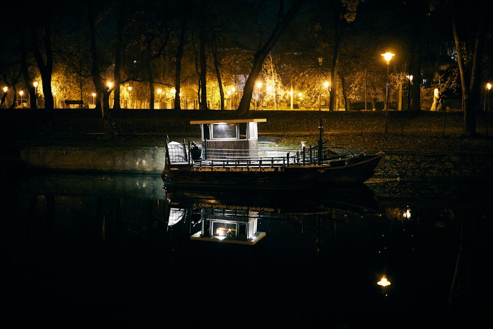 a boat floating on top of a lake at night
