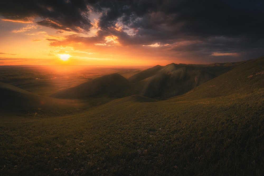 a sunset over a hill