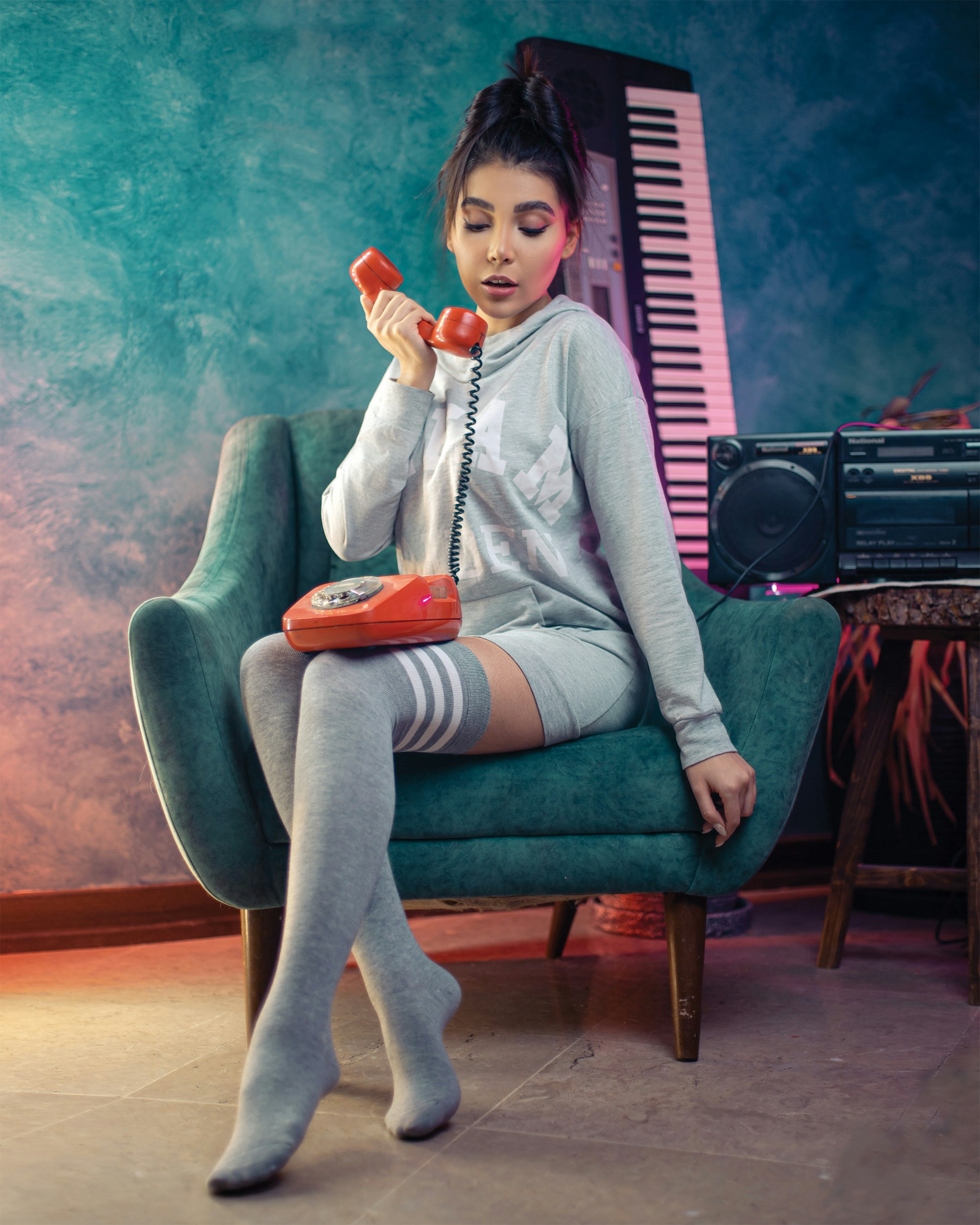 seorang wanita duduk di kursi berbicara di telepon