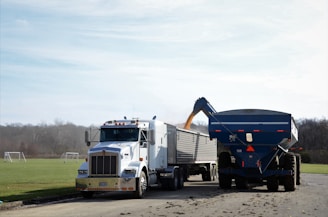 a dump truck and a large blue dump truck on a road