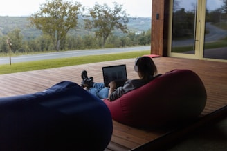 a person sitting on a bean bag chair using a laptop