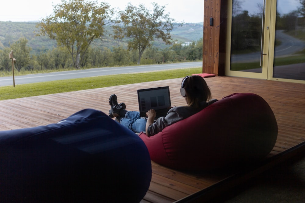 a person sitting on a bean bag chair using a laptop