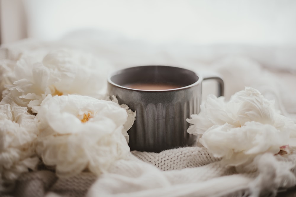 a cup of coffee sitting on top of a blanket