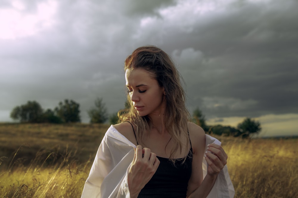 a woman standing in a field of tall grass