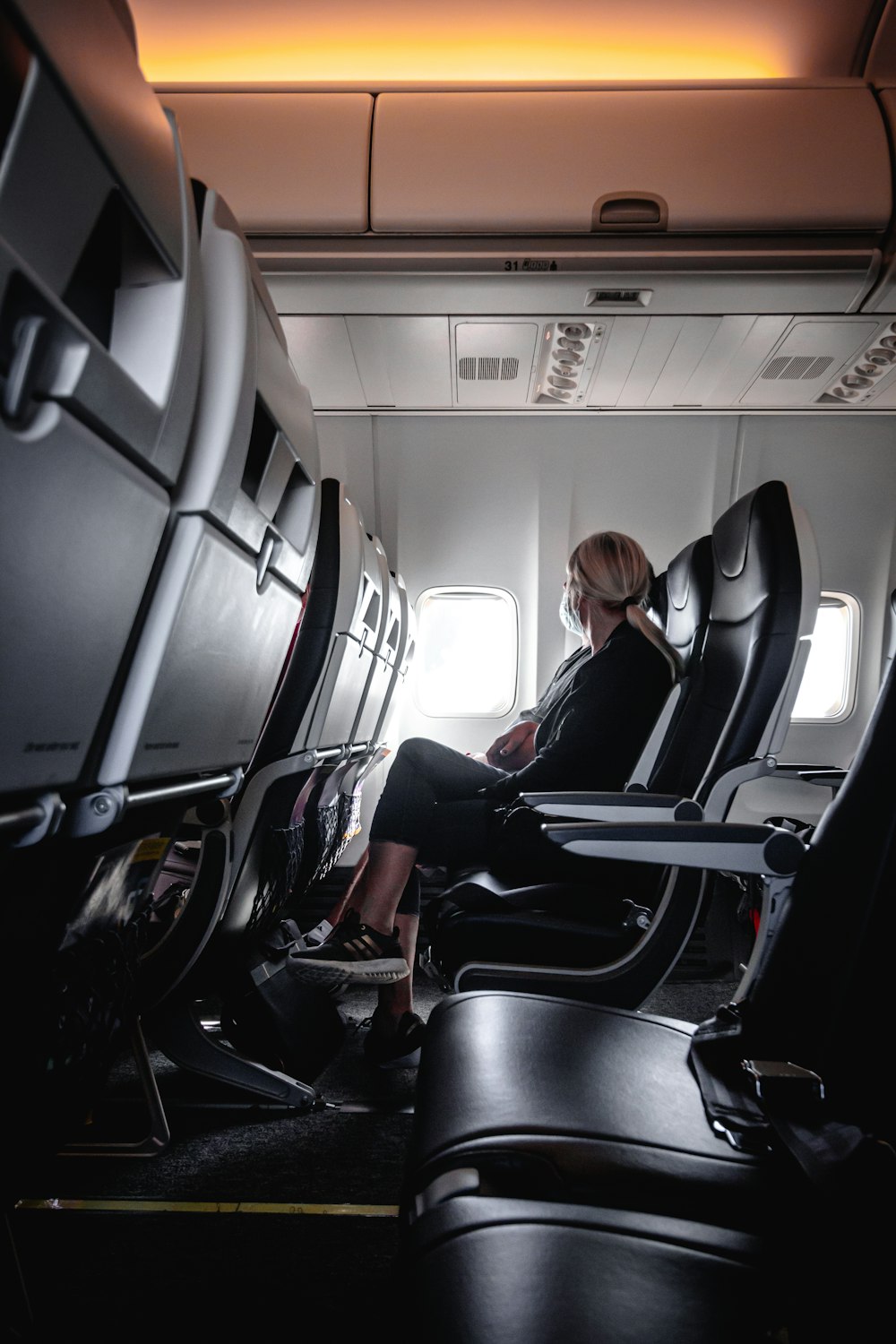 a woman sitting in a seat on an airplane