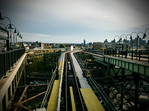 Engineers inspecting railway tracks with a backdrop of a bustling city skyline.