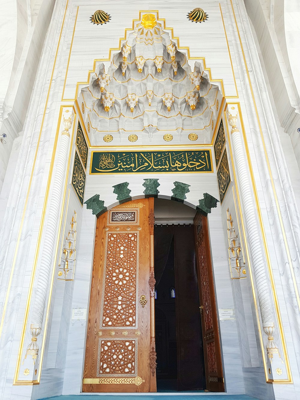 a large wooden door sitting inside of a white building