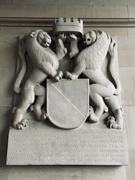 a statue of two lions holding a shield
