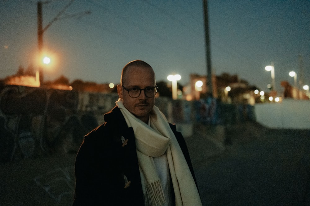 a man with glasses and a white scarf