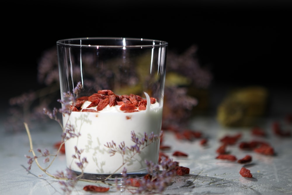 a glass filled with yogurt sitting on top of a table