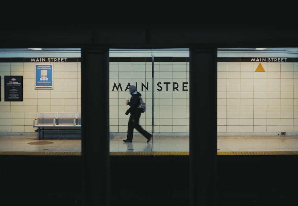 a person walking down a subway platform at night