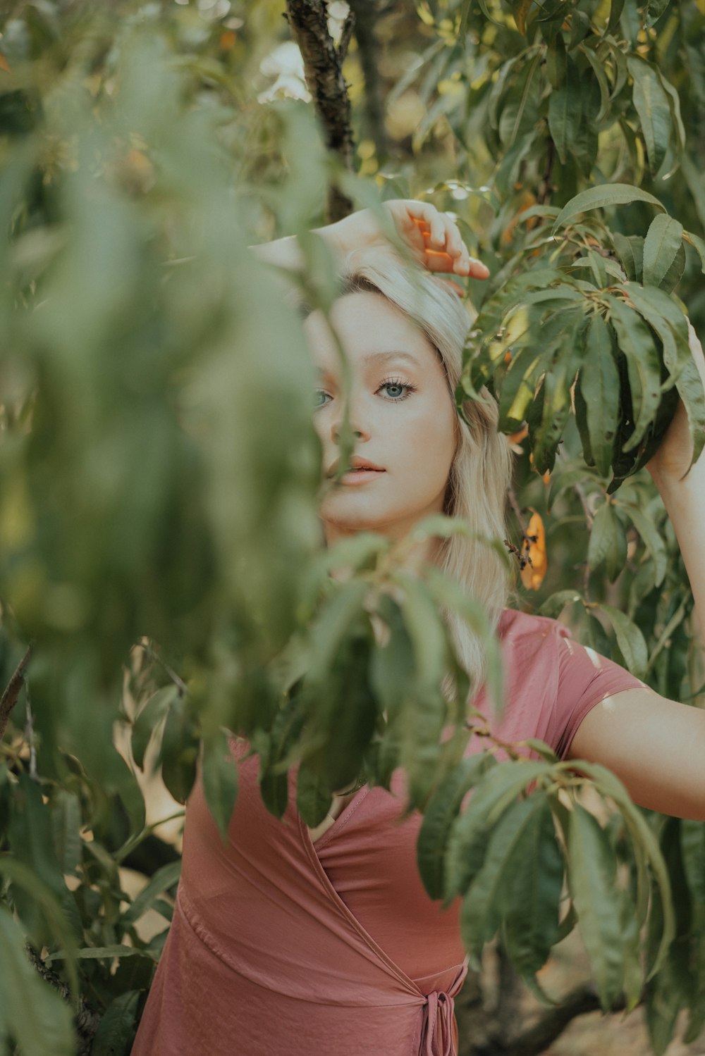 a woman standing in a tree with her hands on her head