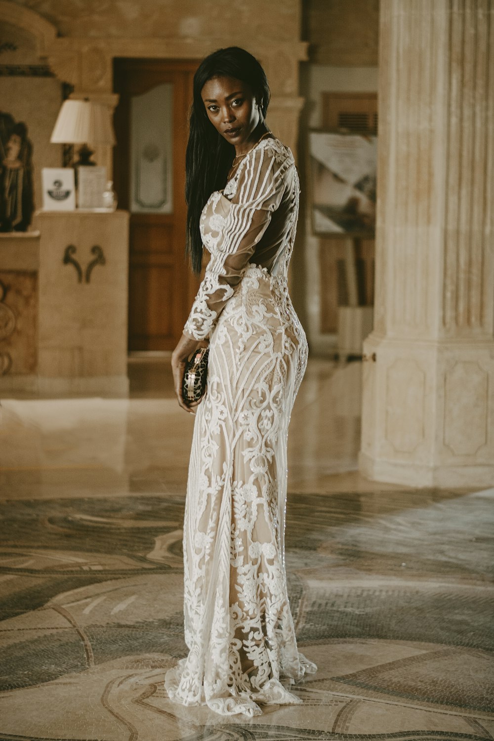 a woman in a white dress standing in a room