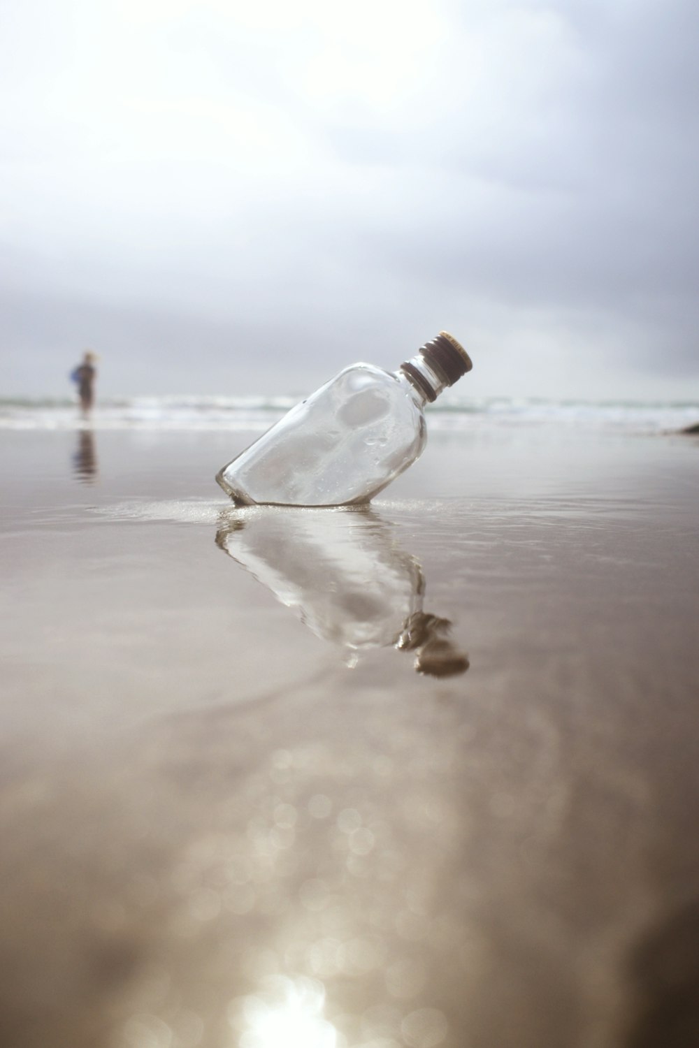a bottle that is sitting in the sand