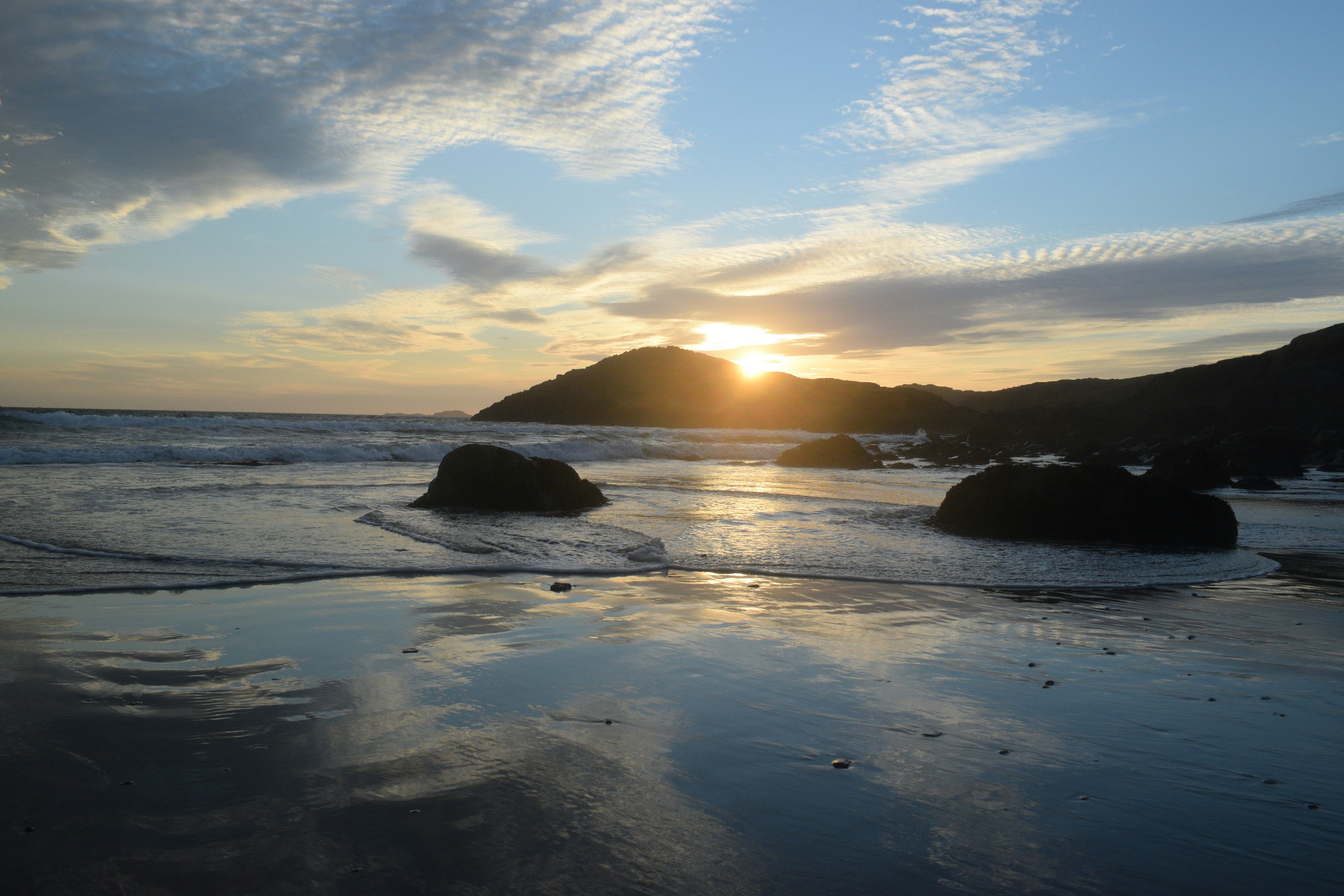 Le soleil se couche sur l’eau à la plage