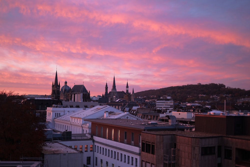 Blick auf eine Stadt bei Sonnenuntergang mit rosa Himmel
