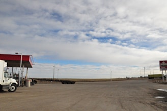 A Devote National truck refueling at a quiet rest stop under a clear blue sky.