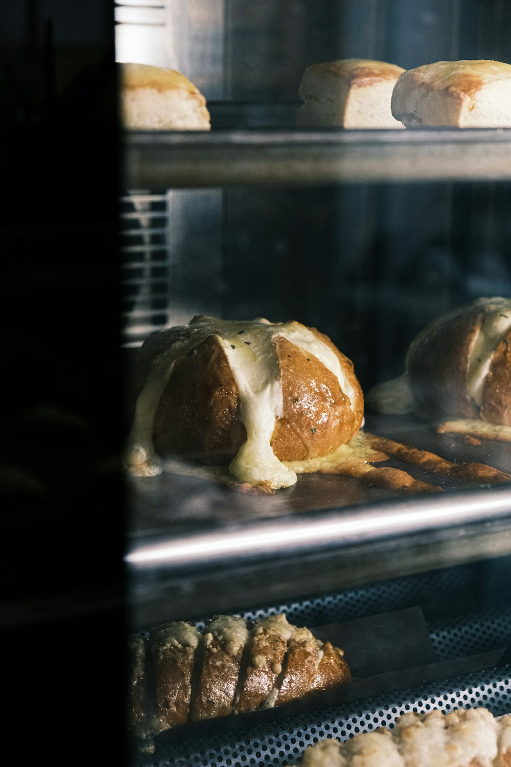 a bunch of breads that are in a glass case