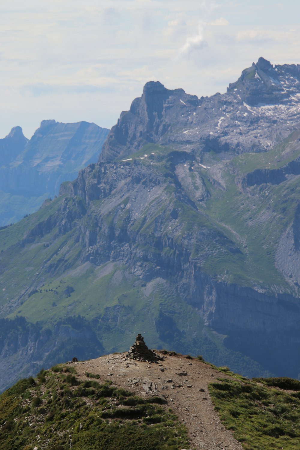a person sitting on top of a hill with a mountain in the background