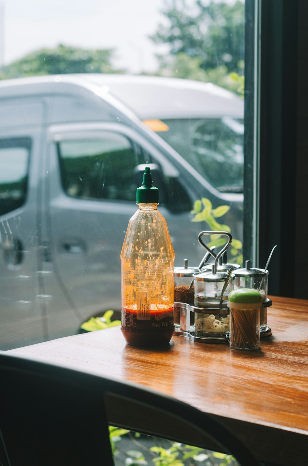 a bottle of liquid sitting on top of a wooden table