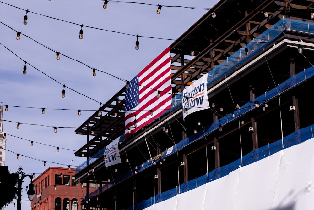 a large american flag hanging from the side of a building