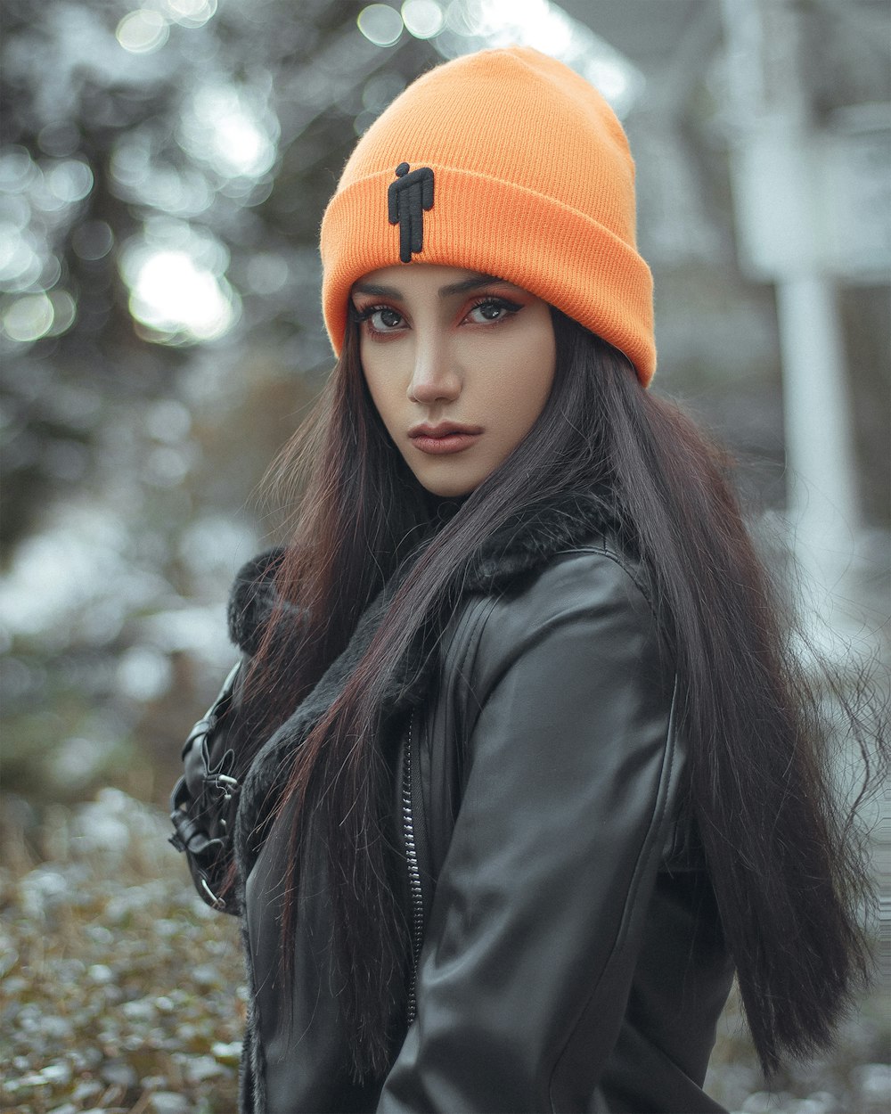 a woman with long hair wearing an orange beanie