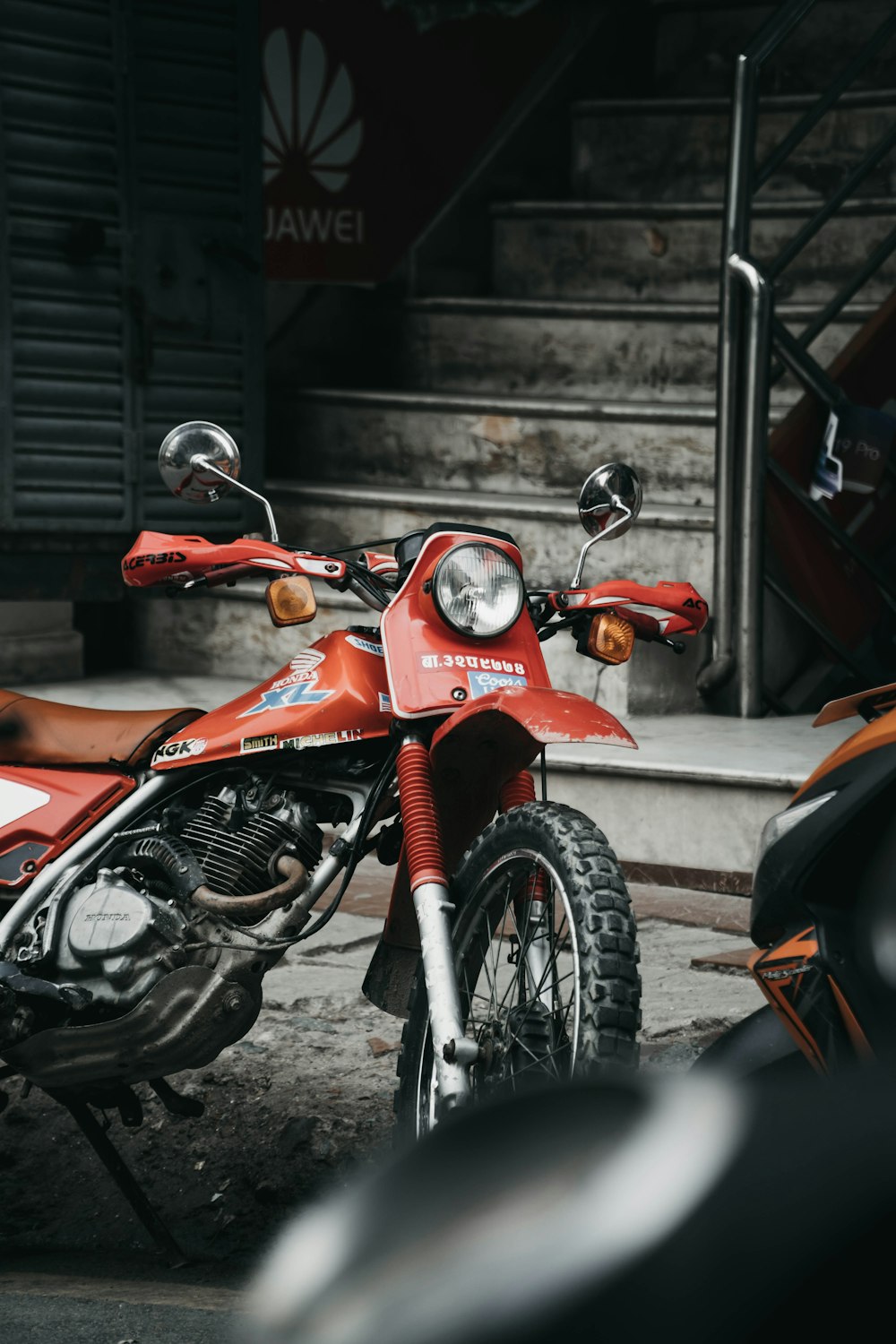 a red motorcycle parked in front of a building