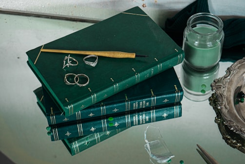 A stack of graphic novels and collectibles on a sleek black and green desk.