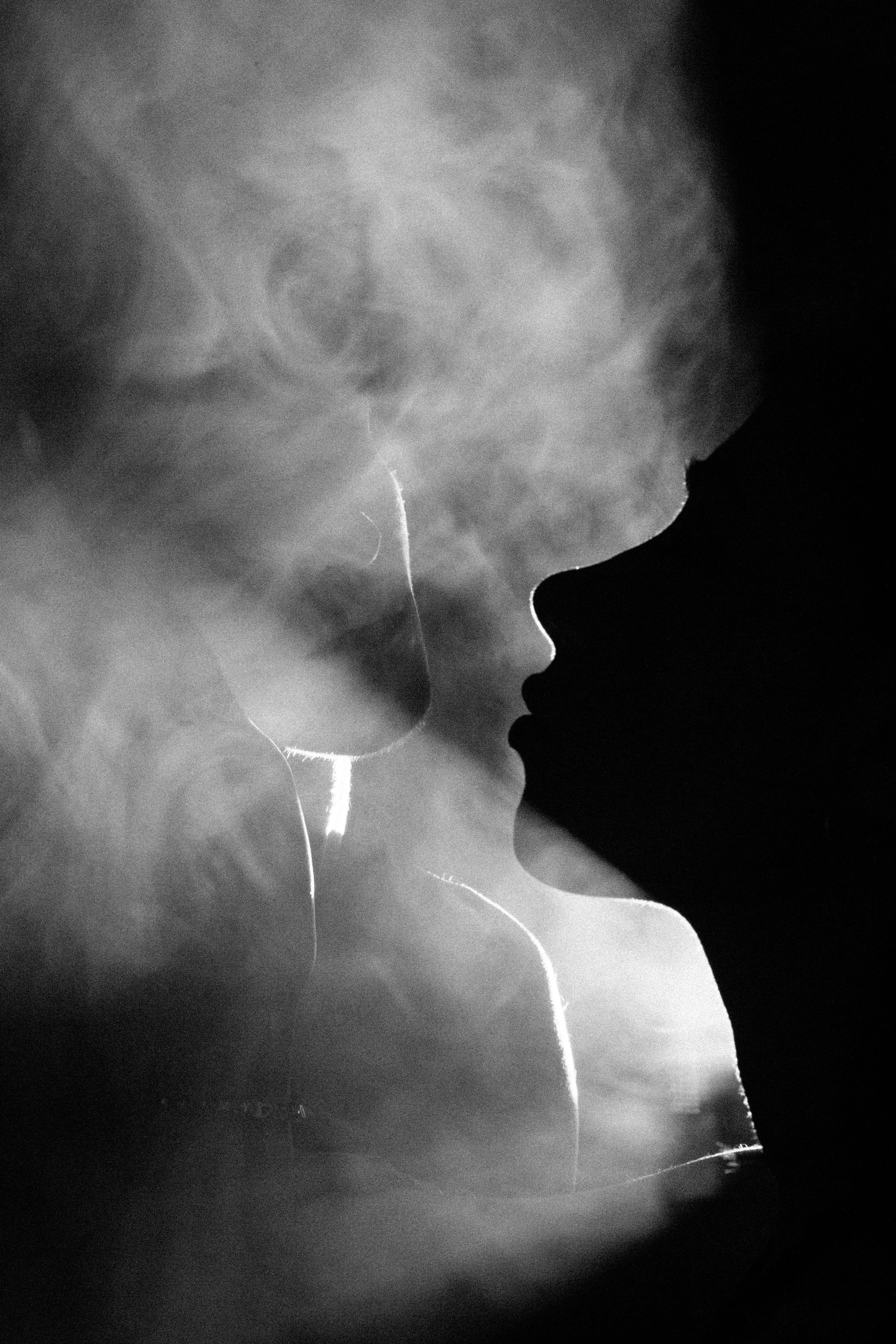 a black and white photo of a woman's face in smoke