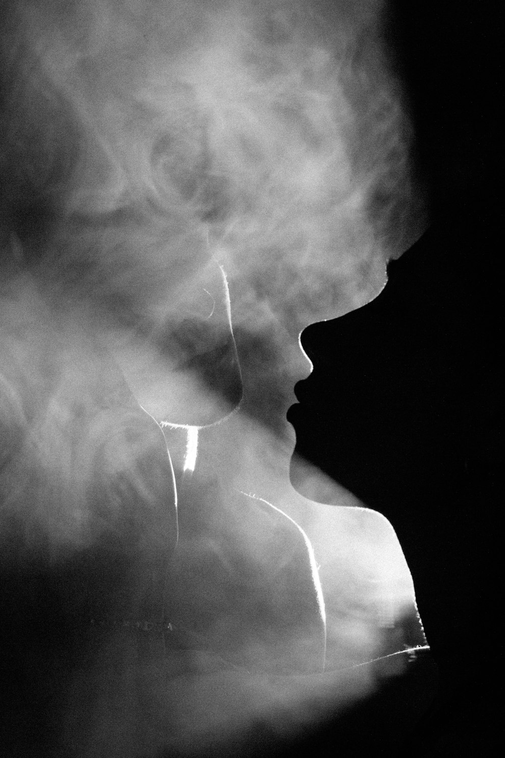 a black and white photo of a woman's face in smoke