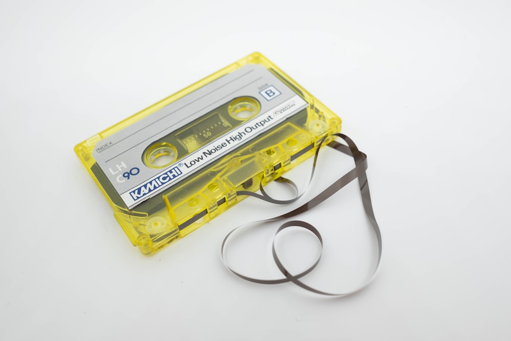 a yellow cassette cassette with a black strap