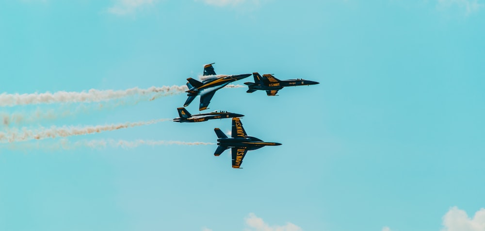 a group of fighter jets flying through a blue sky